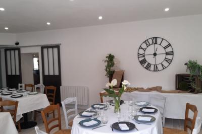 Table avec machine à café, carafe de punch, verres, snacks salés et bouteilles de vin dans un cadre convivial.
