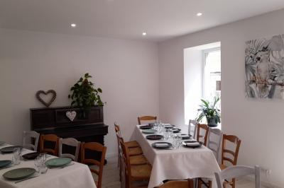 Table avec machine à café, carafe de punch, verres, snacks salés et bouteilles de vin dans un cadre convivial.