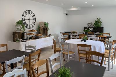 Table avec machine à café, carafe de punch, verres, snacks salés et bouteilles de vin dans un cadre convivial.