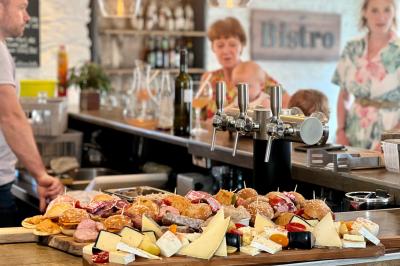 Table avec machine à café, carafe de punch, verres, snacks salés et bouteilles de vin dans un cadre convivial.