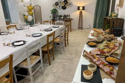 Table avec machine à café, carafe de punch, verres, snacks salés et bouteilles de vin dans un cadre convivial.
