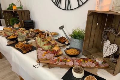 Table avec machine à café, carafe de punch, verres, snacks salés et bouteilles de vin dans un cadre convivial.