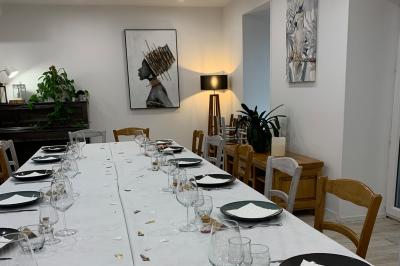 Table avec machine à café, carafe de punch, verres, snacks salés et bouteilles de vin dans un cadre convivial.