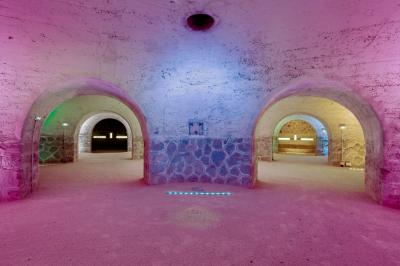 Deux structures en pierre recouvertes de végétation dans un espace herbeux entouré d'arbres.