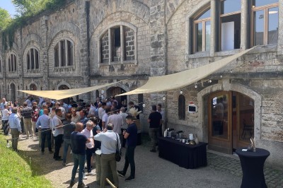 Intérieur d'une structure voûtée en pierre, éclairée par des lumières colorées roses, bleues et vertes.