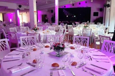 Kiosque en toit de chaume entouré d'arbres, situé dans une cour pavée avec des voiles d'ombrage.