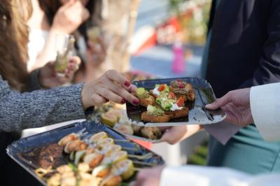 Plateau de mini-sandwichs variés, verrines et décorations florales comestibles, présenté sur une table.