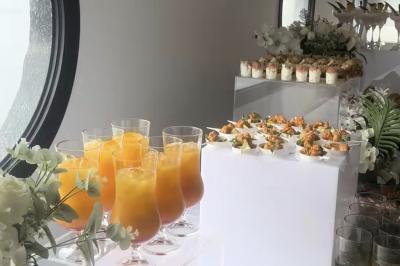 Plateau de mini-sandwichs variés, verrines et décorations florales comestibles, présenté sur une table.