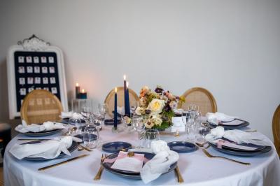 Espace extérieur avec sol en gravier, arbres, tente beige tendue et clôture en bois sous un ciel nuageux.