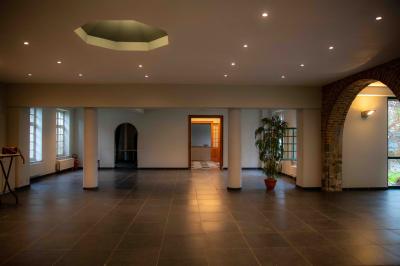 Salle vide avec de grandes baies vitrées donnant sur un espace extérieur verdoyant.