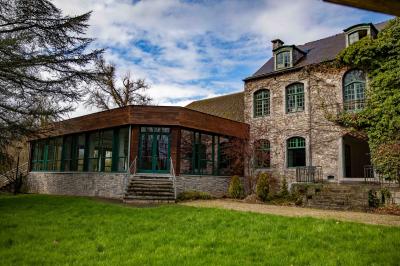 Salle vide avec de grandes baies vitrées donnant sur un espace extérieur verdoyant.
