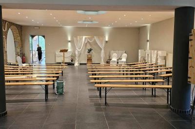 Salle vide avec de grandes baies vitrées donnant sur un espace extérieur verdoyant.