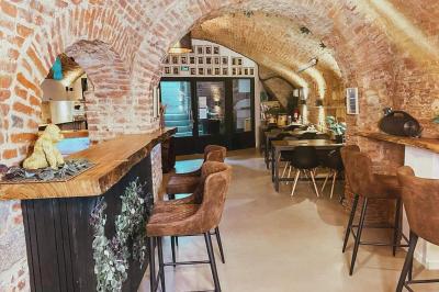 Lavabo blanc avec miroir dans une pièce aux murs en pierre et éclairée par des lampes suspendues rondes.
