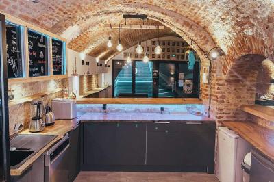 Lavabo blanc avec miroir dans une pièce aux murs en pierre et éclairée par des lampes suspendues rondes.