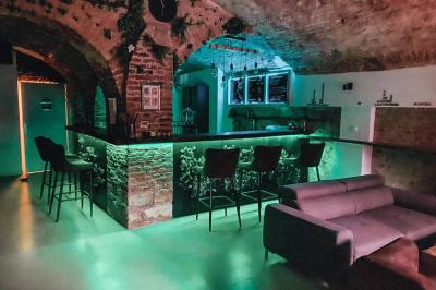 Lavabo blanc avec miroir dans une pièce aux murs en pierre et éclairée par des lampes suspendues rondes.