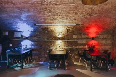 Lavabo blanc avec miroir dans une pièce aux murs en pierre et éclairée par des lampes suspendues rondes.