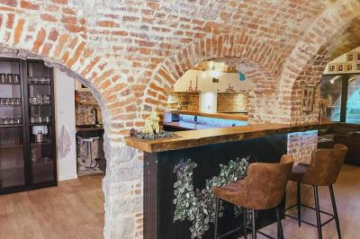 Lavabo blanc avec miroir dans une pièce aux murs en pierre et éclairée par des lampes suspendues rondes.