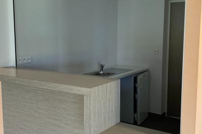 Salle de réception décorée avec des tables dressées, nappes blanches, serviettes rouges et centre de table fleuri.