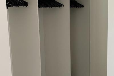 Salle de réception décorée avec des tables dressées, nappes blanches, serviettes rouges et centre de table fleuri.