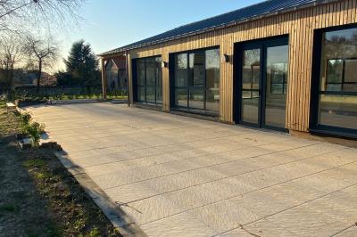 Des chèvres se tiennent près d'une clôture dans un champ herbeux entouré de barrières en bois.