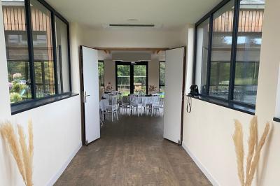 Des chèvres se tiennent près d'une clôture dans un champ herbeux entouré de barrières en bois.