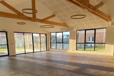 Présentoirs de lunettes de soleil exposés dans une salle lumineuse avec vue sur un espace extérieur verdoyant.