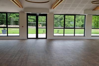 Présentoirs de lunettes de soleil exposés dans une salle lumineuse avec vue sur un espace extérieur verdoyant.