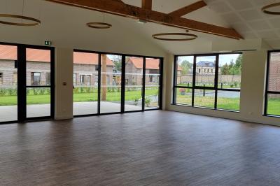 Présentoirs de lunettes de soleil exposés dans une salle lumineuse avec vue sur un espace extérieur verdoyant.