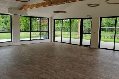 Présentoirs de lunettes de soleil exposés dans une salle lumineuse avec vue sur un espace extérieur verdoyant.