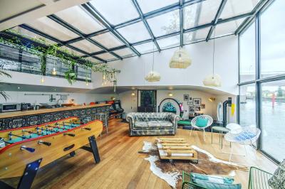 Décoration intérieure avec guirlandes lumineuses, sapin de Noël et vue sur des bâtiments à travers une verrière.