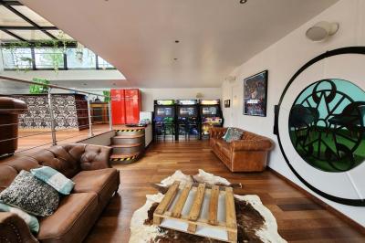 Décoration intérieure avec guirlandes lumineuses, sapin de Noël et vue sur des bâtiments à travers une verrière.