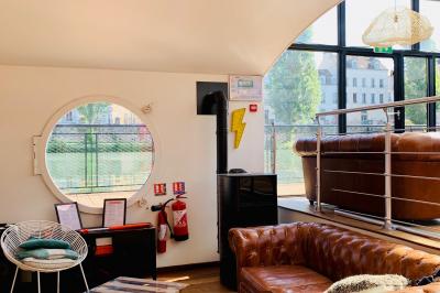 Groupe de personnes réunies dans un bar extérieur animé avec terrasse, palmiers et guirlandes lumineuses.