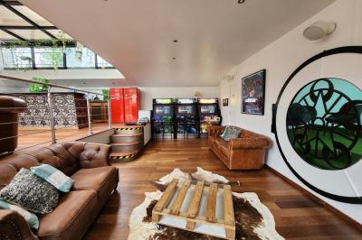 Groupe de personnes réunies dans un bar extérieur animé avec terrasse, palmiers et guirlandes lumineuses.