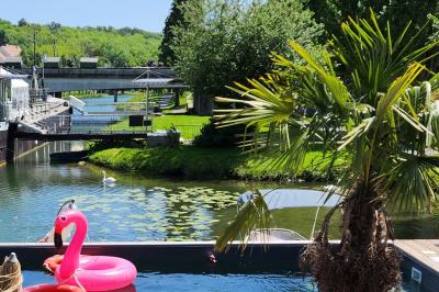 Groupe de personnes réunies dans un bar extérieur animé avec terrasse, palmiers et guirlandes lumineuses.