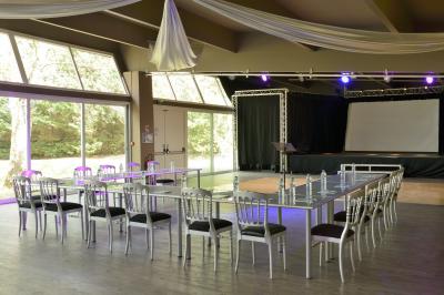 Allée pavée bordée d'arbres et de bâtiments en bois dans un cadre verdoyant sous un ciel dégagé.