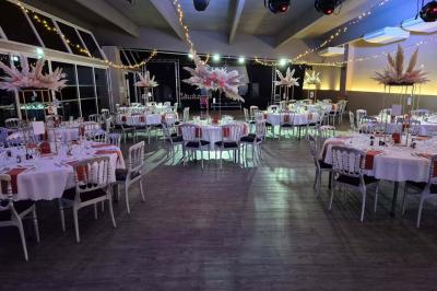 Allée pavée bordée d'arbres et de bâtiments en bois dans un cadre verdoyant sous un ciel dégagé.