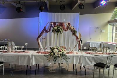 Allée pavée bordée d'arbres et de bâtiments en bois dans un cadre verdoyant sous un ciel dégagé.