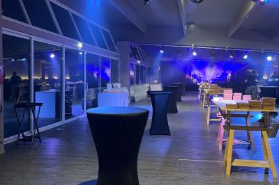 Allée pavée bordée d'arbres et de bâtiments en bois dans un cadre verdoyant sous un ciel dégagé.