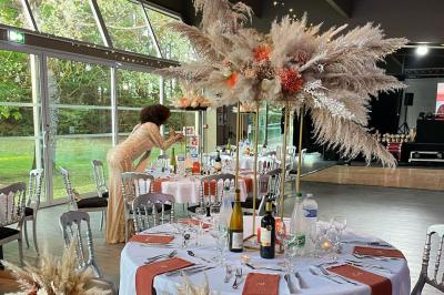 Allée pavée bordée d'arbres et de bâtiments en bois dans un cadre verdoyant sous un ciel dégagé.