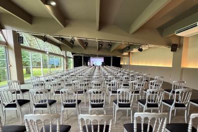 Allée pavée bordée d'arbres et de bâtiments en bois dans un cadre verdoyant sous un ciel dégagé.