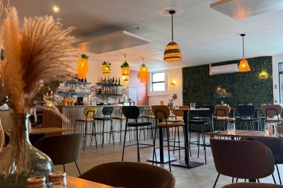 Miniature Location salle Déville-lès-Rouen (Seine-Maritime) - La Casa Caliente #4 Comptoir en bois avec tabourets colorés, décor tropical et luminaires en osier dans un bar lumineux.