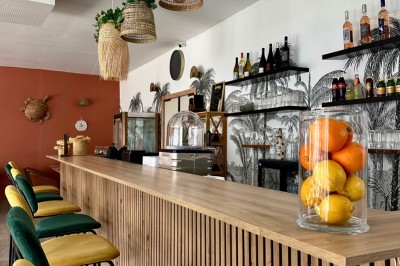 Miniature Location salle Déville-lès-Rouen (Seine-Maritime) - La Casa Caliente #15 Comptoir en bois avec tabourets colorés, décor tropical et luminaires en osier dans un bar lumineux.