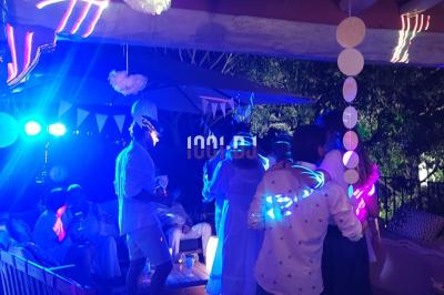 Des artistes en costumes brillants dansent sur une scène illuminée par des projecteurs colorés et un écran lumineux.