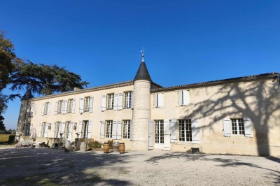 Lampe solaire de jardin en gros plan, éclairant un chemin bordé de feuilles mortes dans un parc au coucher du soleil.