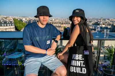 Trois hommes souriants posent ensemble dans un espace professionnel lors d'un événement, badges autour du cou.