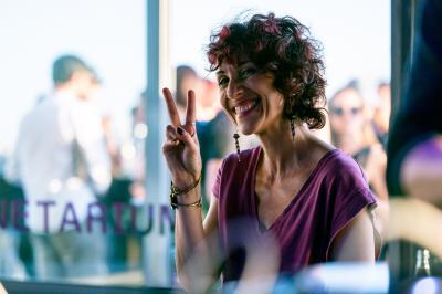Trois hommes souriants posent ensemble dans un espace professionnel lors d'un événement, badges autour du cou.