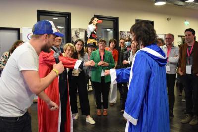 Miniature Social Bar #4 Une personne tient un jeu coloré avec une roue et des compartiments, marqué ’Le Social Bar’.