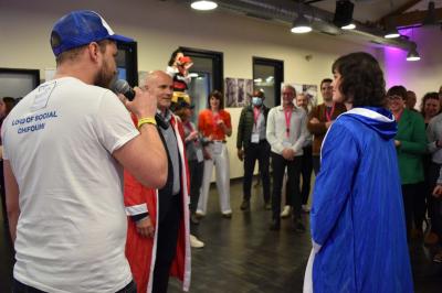 Miniature Social Bar #5 Une personne tient un jeu coloré avec une roue et des compartiments, marqué ’Le Social Bar’.