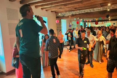 Miniature Social Bar #2 Une personne tient un jeu coloré avec une roue et des compartiments, marqué ’Le Social Bar’.