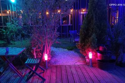 Rondin de bois gravé ’Chantal’ avec des cœurs, posé sur une serviette blanche avec une branche d'olivier.